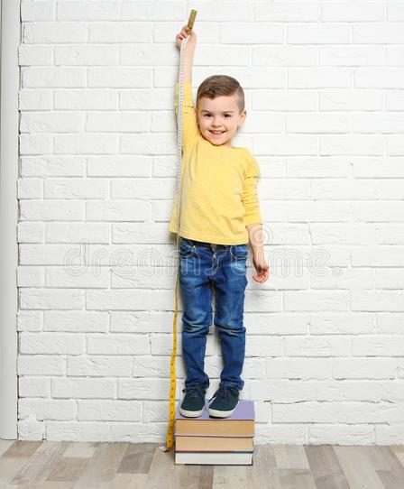 little boy measuring his height near wall brick 115308635 1 How your height increases every morning ? हर सुबह आपका कद कैसे बढ़ जाता है ?